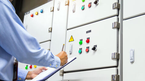 Eine Person prüft den Schaltkasten einer Lüftungsanlage.