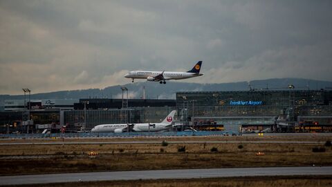 Ein Flugzeug setzt in der Abenddämmerung auf dem Frankfurter Flughafen zur Landung an. 