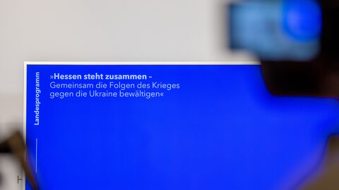 Ein abgefilmter Bildschirm mit der Schrift Hessen steht zusammen