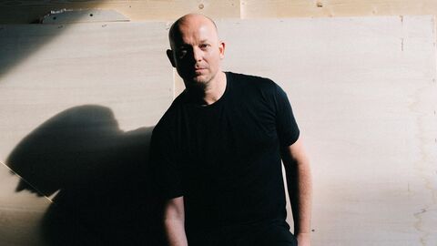 Portrait von Ulrich Rasche, er steht vor einer Wand, hinter ihm wirft sein Körper einen Schatten