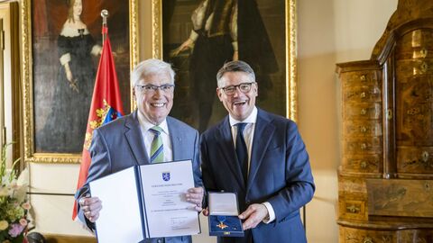 Ministerpräsident Boris Rhein überreicht Rainer Klett das Verdienstkreuz am Bande.