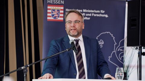 Ein Mann steht an einem Podium und spricht ins Mikrofon.