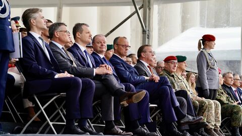 Ministerpräsident Rhein, Bundeskanzler Merz, Verteidiungsminister Pistorius und weitere Personen sitzen zusammen.