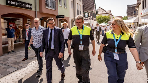 Eröffnung Hessentag 2025 Ministerpräsident Boris Rhein läuft mit zwei Personen in Sicherheitskleidung über die Hessentagsstraße.