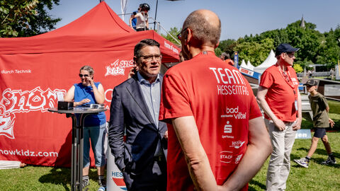 Eröffnung Hessentag 2025 Ministerpräsident Boris Rhein spricht mit einer Person in einem roten T-Shirt