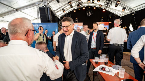 Ministerpräsident Boris Rhein schüttelt die Hand eines Mannes. 