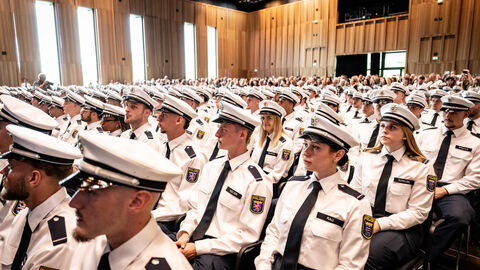 Vereidigung Kommissaranwärter Hessentag 2025 Mehrere Menschen in Uniform sitzen in einer Reihe.
