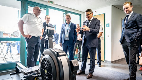 Vereidigung Kommissaranwärter Hessentag 2025 Ministerpräsident Boris Rhein begutachtet ein technisches Gerät.
