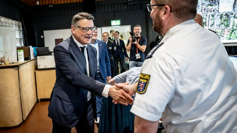 Vereidigung Kommissaranwärter Hessentag 2025 Ministerpräsident Boris Rhein schüttlt die Hand eines Polizisten.