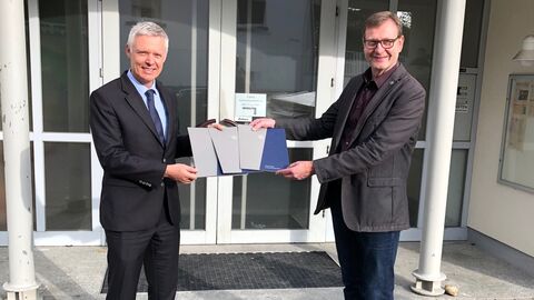 Kultusstaatssekretär Dr. Manuel Lösel überreicht Förderbescheid an Reiskirchens Bürgermeister Dietmar Kromm.