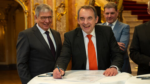 Hessens Finanzminister Professor Dr. R. Alexander Lorz unterzeichnet den Zukunftspakt. Im Bildhintergrund zu sehen sind Wiesbadens Oberbürgermeister Gert-Uwe Mende (links) und Hofbiebers Bürgermeister Markus Röder (rechts).